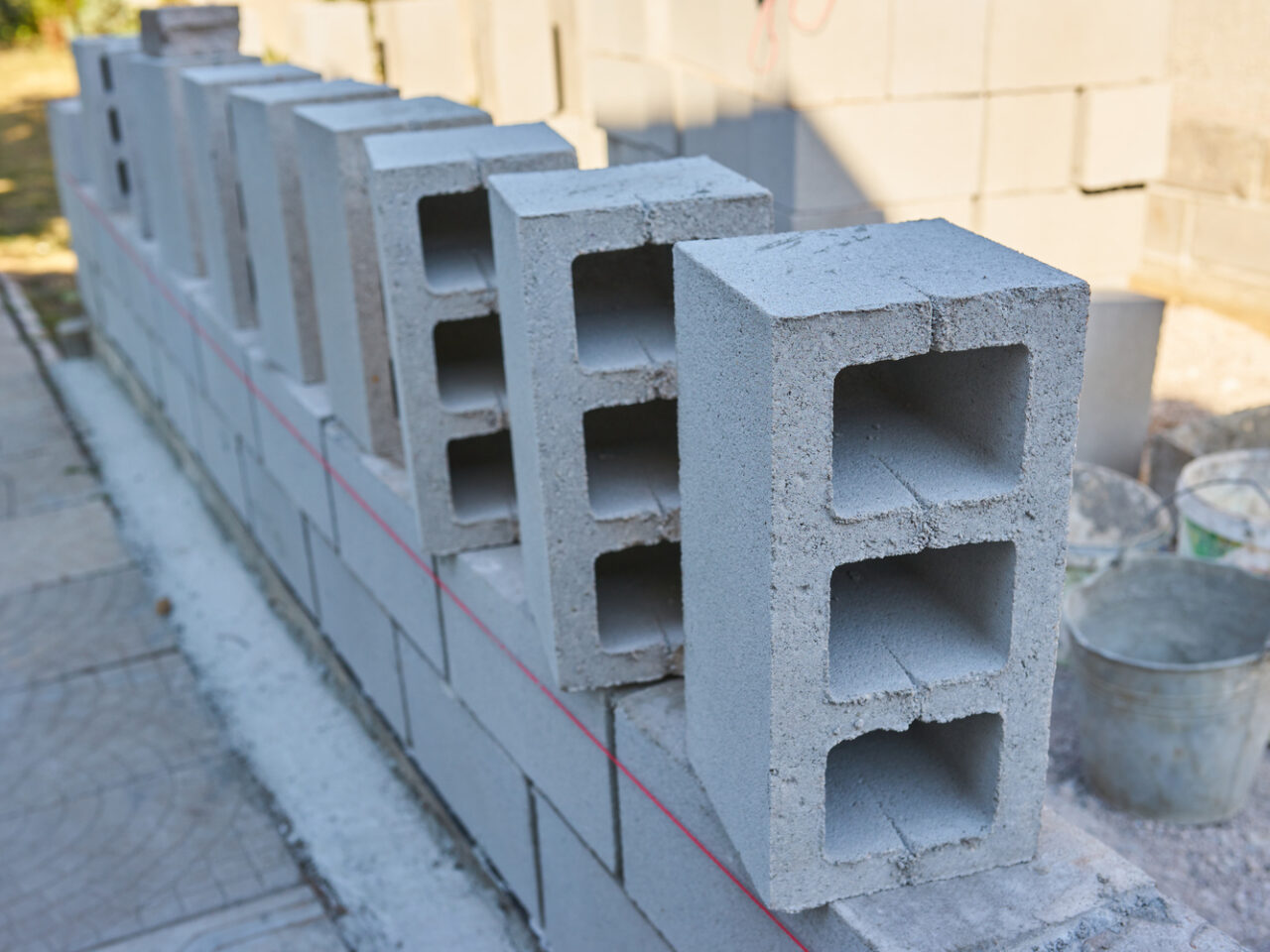 a worker builds a cinder block wall for a new home