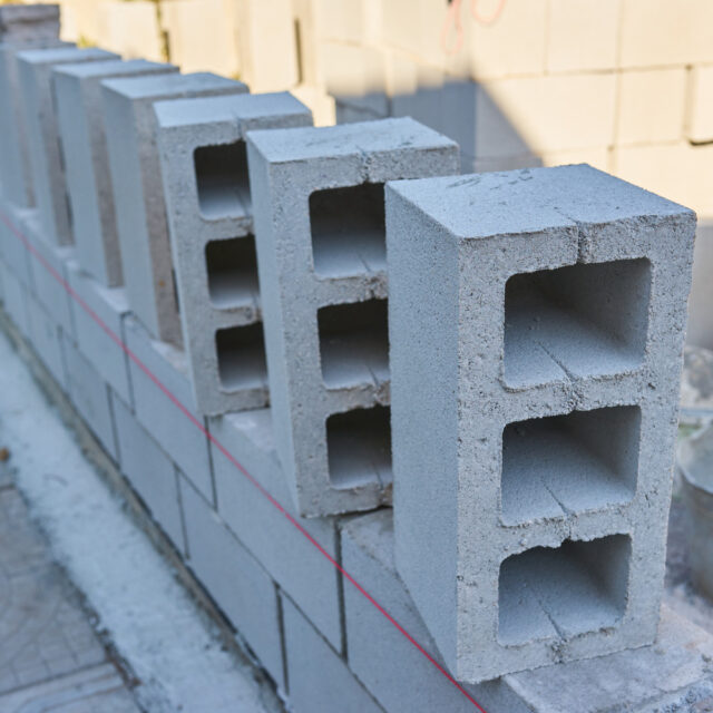 a worker builds a cinder block wall for a new home